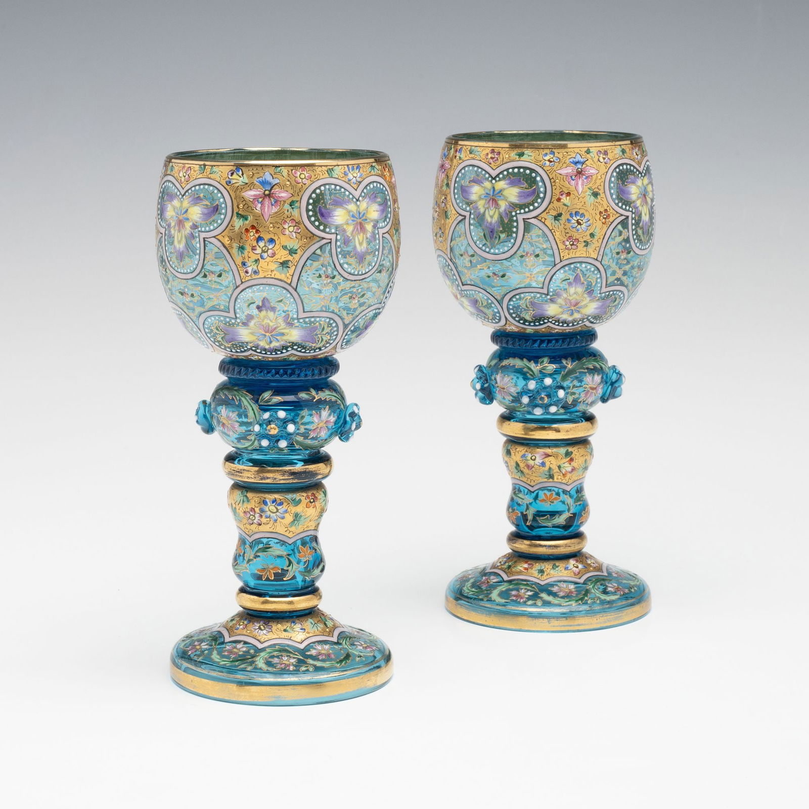ELABORATE MOSER ISLAMIC INFLUENCE ENAMELED WINE GOBLETS: Ludwig Moser Early 20th Century Each blue gem tone crystal wine goblet has a bulbus bowl with elaborate gilding and enamel decoration in Moser's familiar motif of Islamic influence designs in colorful