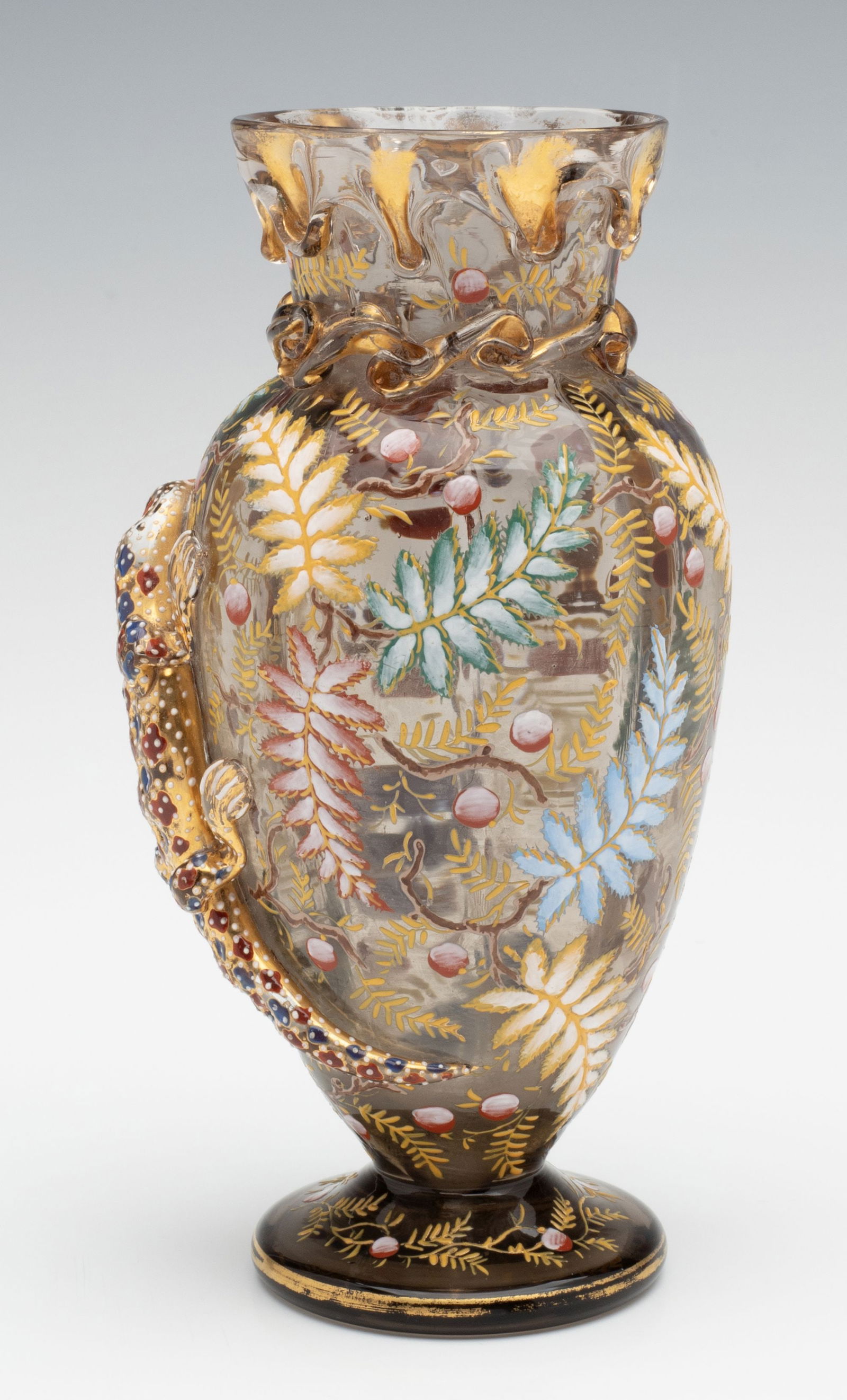 A MOSER ART GLASS VASE WITH APPLIED SALAMANDER: Ludwig Moser Early 20th Century The smoky topaz colored vase is adorned with applied lava-like gilded glass applications at the rim above a collar of rigaree over the applied figure of a salamander co
