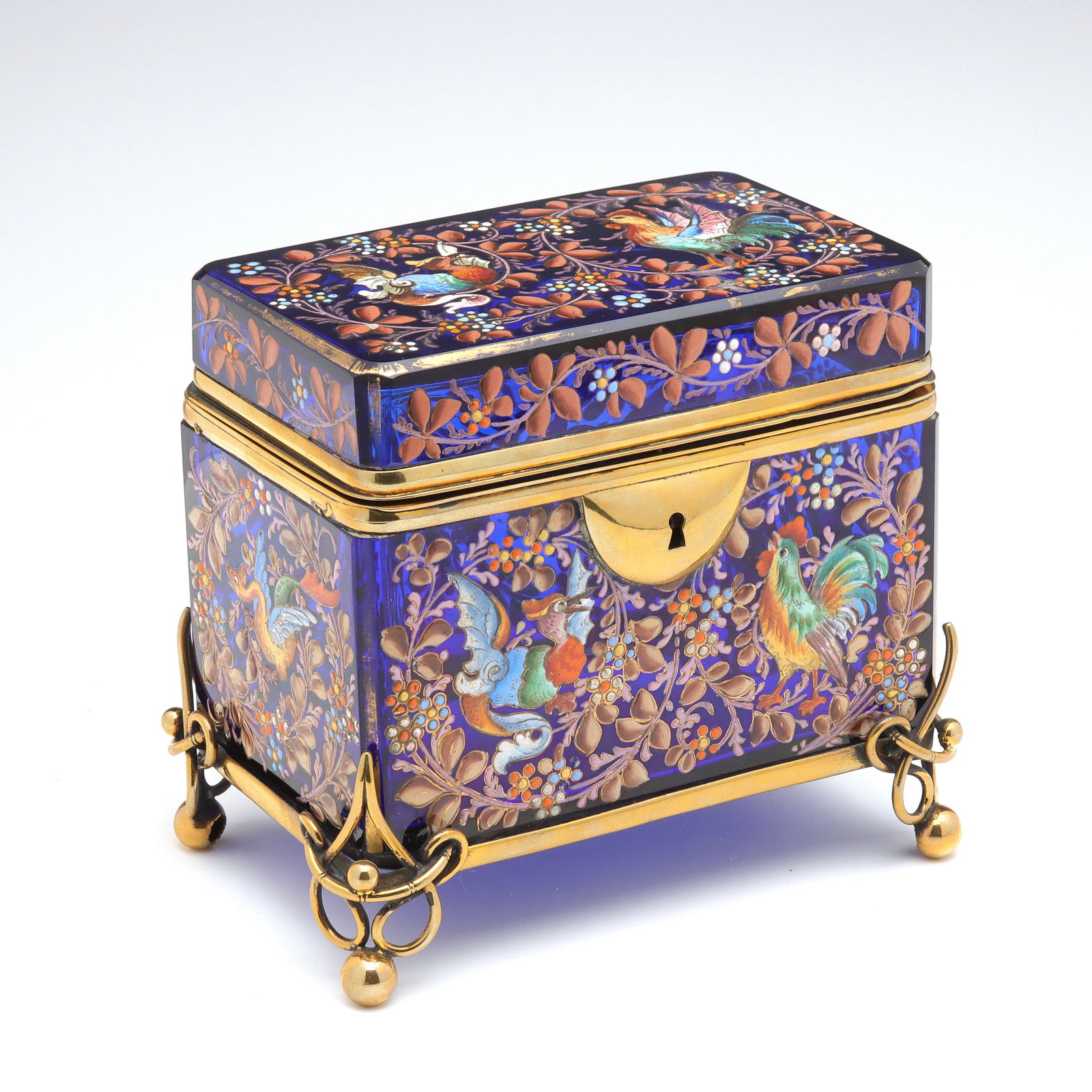 A VERY FINE BRILLIANT BLUE 19TH C. MOSER ART GLASS BOX: Ludwig Moser(Third quarter of the 19th Century.)The sapphire blue art glass box is decorated in thick polychrome enamel depictions of roosters on one end in colorful enamel facing mythical birds oppos
