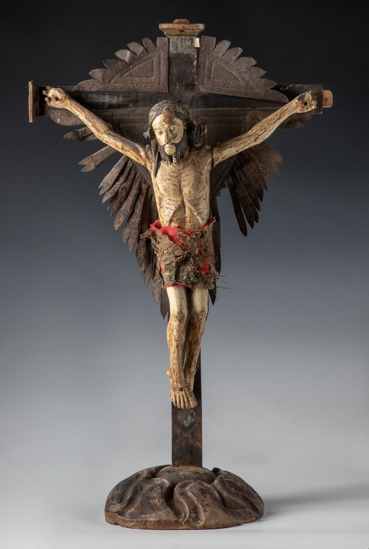 AN 18TH CENTURY BULTO SCULPTURE OF THE CRUCIFIXION: The detailed sculpture involves a carved wood figure of Christ painted in white with dark hair and beard retaining a very old cloth wrap, the simple wood cross, possibly stained or darkened with age,