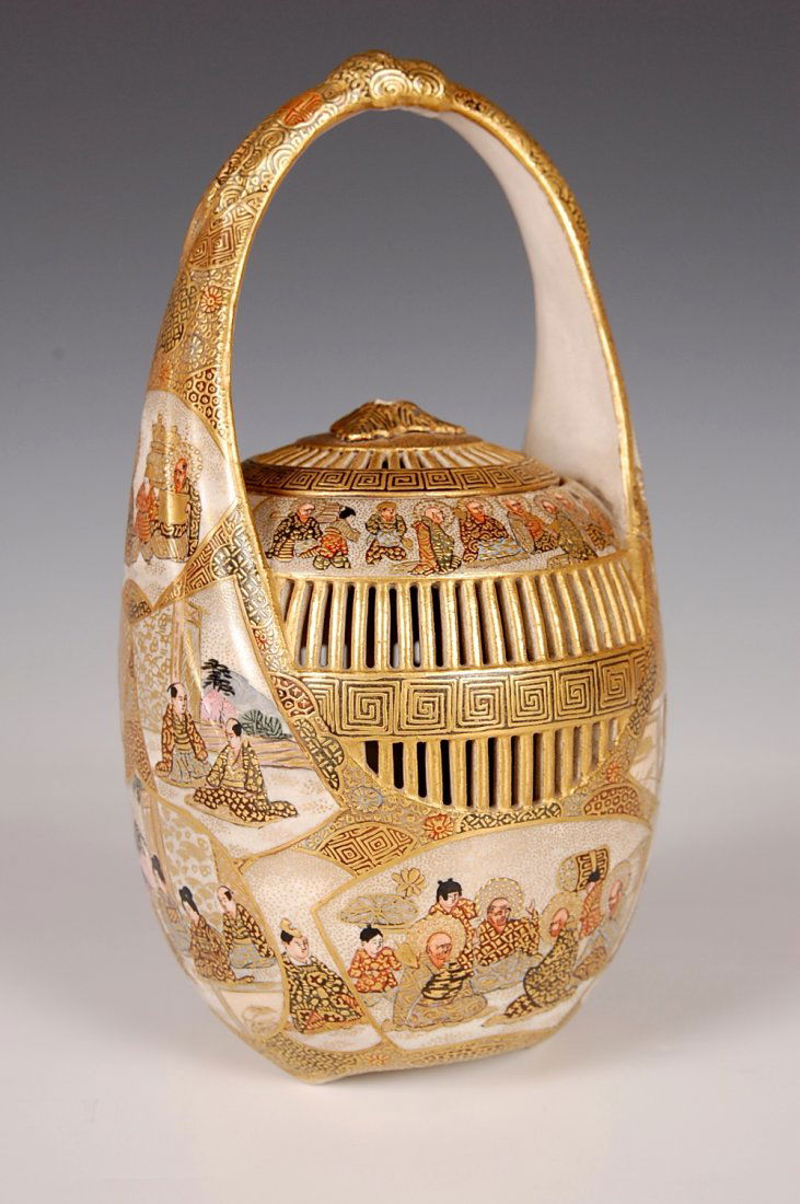LATE 19TH CENTURY JAPANESE SATSUMA CRICKET CAGE: Earthenware basket form with lattice sides, pierced lid, and ribbon handle all decorated with figural designs in enamels and gold encircling the shoulder and body and rising up the sides. Satsuma Mark
