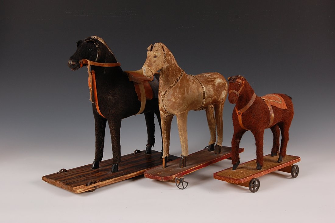 THREE 19TH-C. HORSE ON PLATFORM PULL TOYS: The largest measures 13 x 5 x 13 inches.