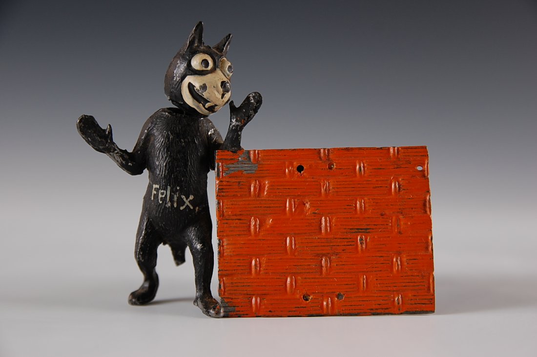 FELIX DIE-CAST NODDER STANDING AT FENCE: With a menu board or other similar function, marked Germany, missing his tail that would act as an easel stand. Measures 3 x 4 Inches