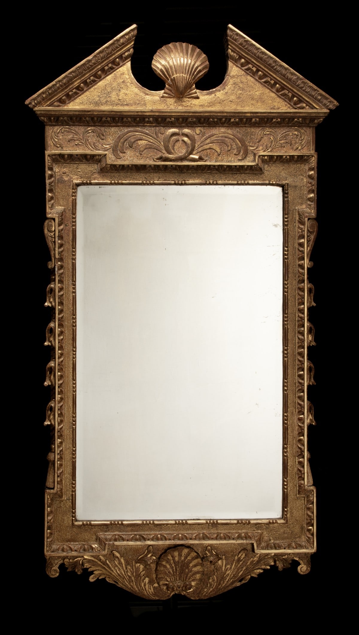 A VERY FINE GEORGE II 18TH CENTURY GILTWOOD MIRROR: The exceptional example with open pediment and central shell above a peddled surface frieze of plumes in relief over the plate with beveled edge flanked by bell flowers and half tassels down each side