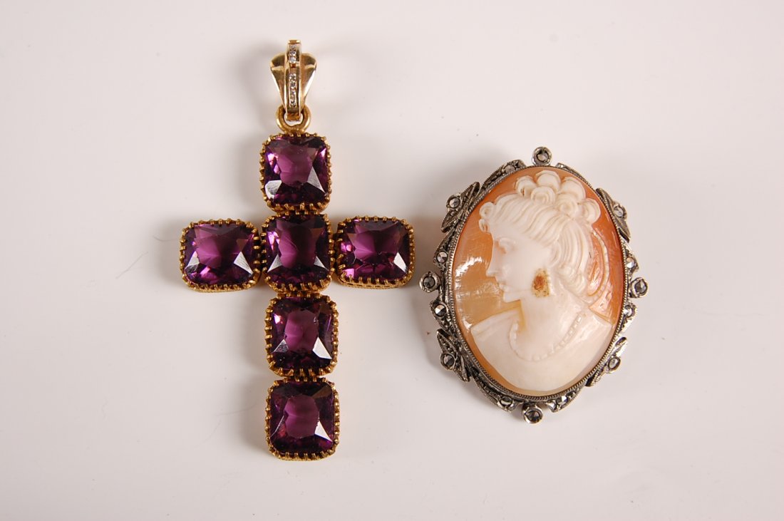 ANTIQUE CARVED SHELL CAMEO AND AMETHYST CROSS PENDANT: Carved shell cameo in sterling silver bezel with marcasites. Plus a cross made up of amethyst colored stones with later bail that appears to be gold and has channel set diamonds. Cross measures 2.75"