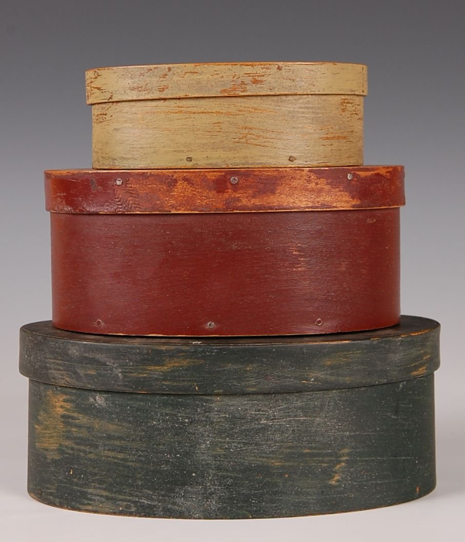 THREE STACKED OVAL PANTRY BOXES: Blue, red and ivory paint. Measures from 7.25 to 5 inches.