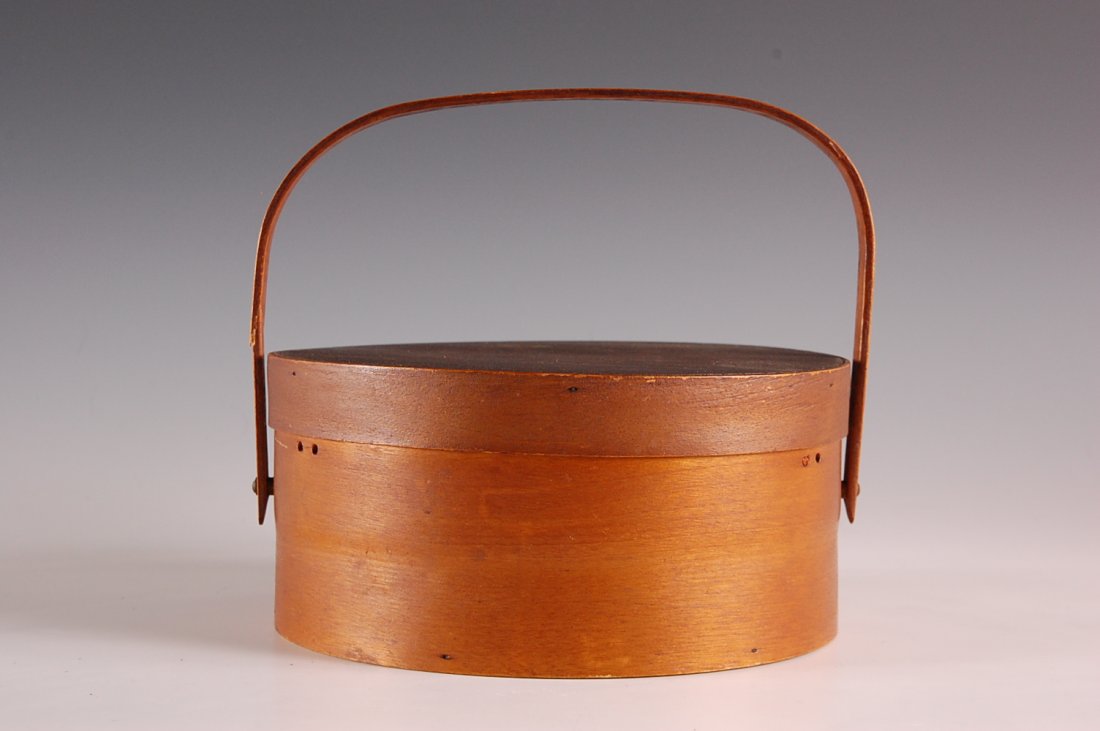 GOOD SWING HANDLE CIRCULAR BENTWOOD SEWING BOX: Silk lined interior, Shaker-type handle attachment, ash and pine woods,, good patina. Measures 3.75 x 7.75 inches.