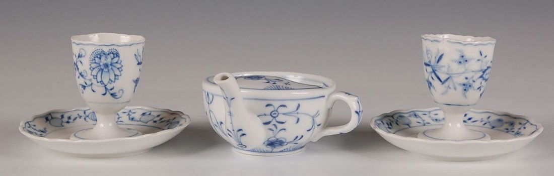 THREE PIECES MEISSEN BLUE ONION: Two egg cups with mark of crossed swords and GERMANY measure 3.5 x 4.5 inches and an unmarked invalid feeder that measures 3 x 5.25 inches.