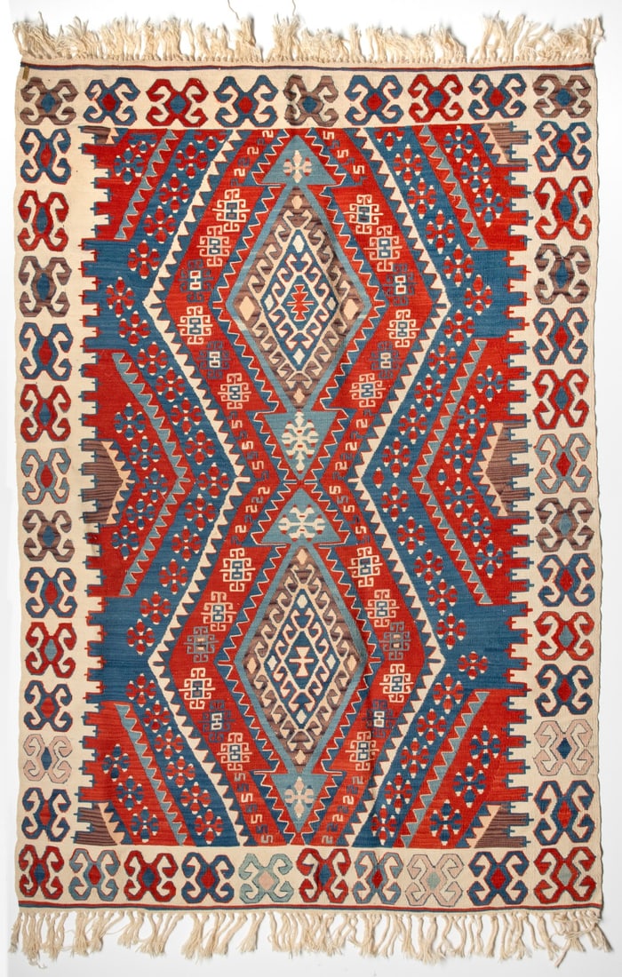 A FINE LATE 20TH CENTURY TURKISH KILIM, CENTRAL TURKIYE: The red and blue diagonal banded field framing two layered hooked rhombus medallions enclosing cruciform flowerheads and hooked squares, within an ivory outer surround with continuous hooked lozenges.