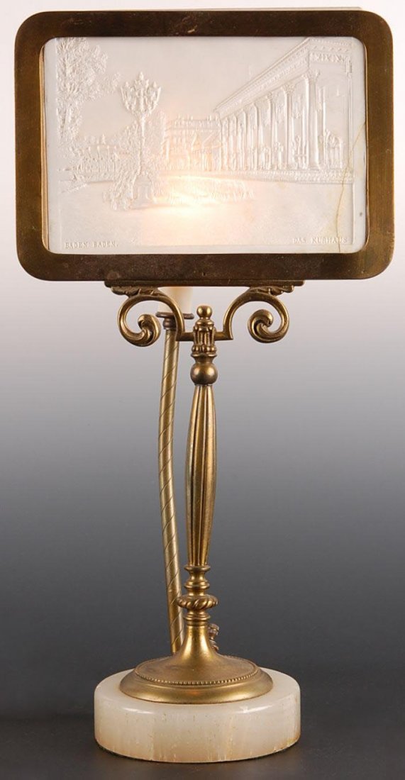 LITHOPHANE DISPLAY LAMP W/ BADEN-BADEN KURHAUS: Stands 18 inches, lithophane measures approximately 6.5 x 9 inches and has a crack lower right edge. Heavy brass frame on next base with chip on edge.