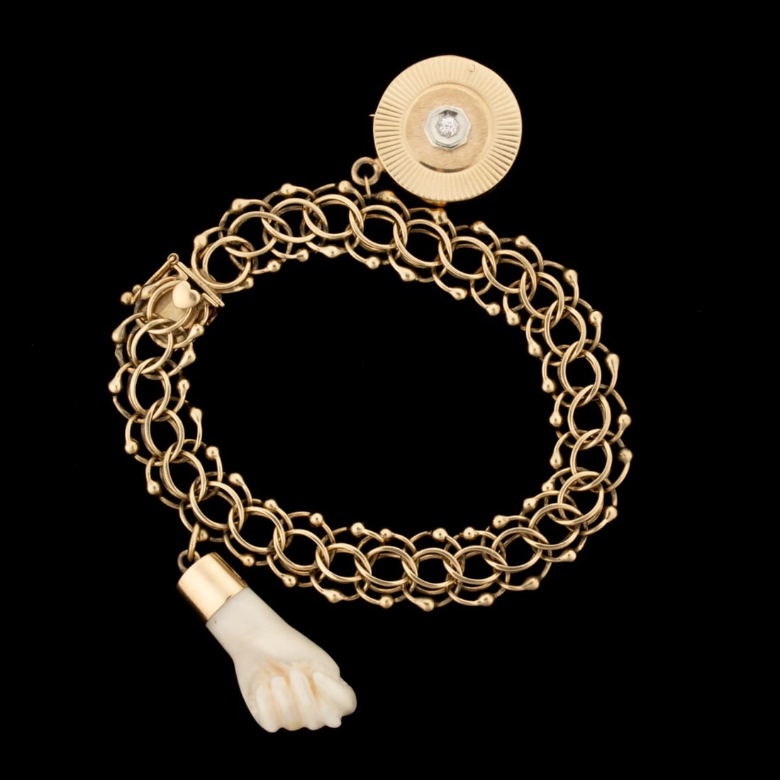 A HANDMADE 14K GOLD CHARM BRACELET: The double loop interlocking bracelet is marked 14k on the clasp, as is the disk form charm. Wrist circumference is 7 inches. Weights 36.1 grams including the charms. Without proof of exemption, be aw