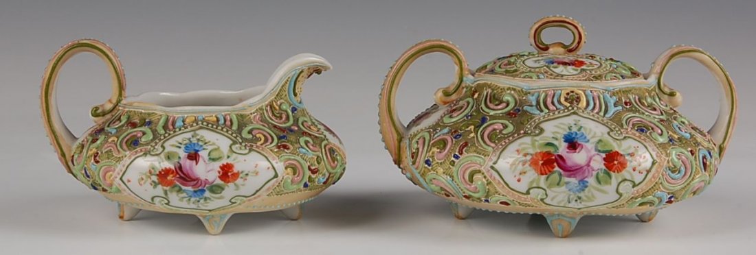 NIPPON MORIAGE CREAMER SUGAR W/ SCENES OF CHICAGO: An unusal example with typical Nippon characteristics and thick moriage decoration, but also decorated with transfer scenes of Chicago. Creamer measures 3 x 4.75 inches, sugar 3 x 5 inches.