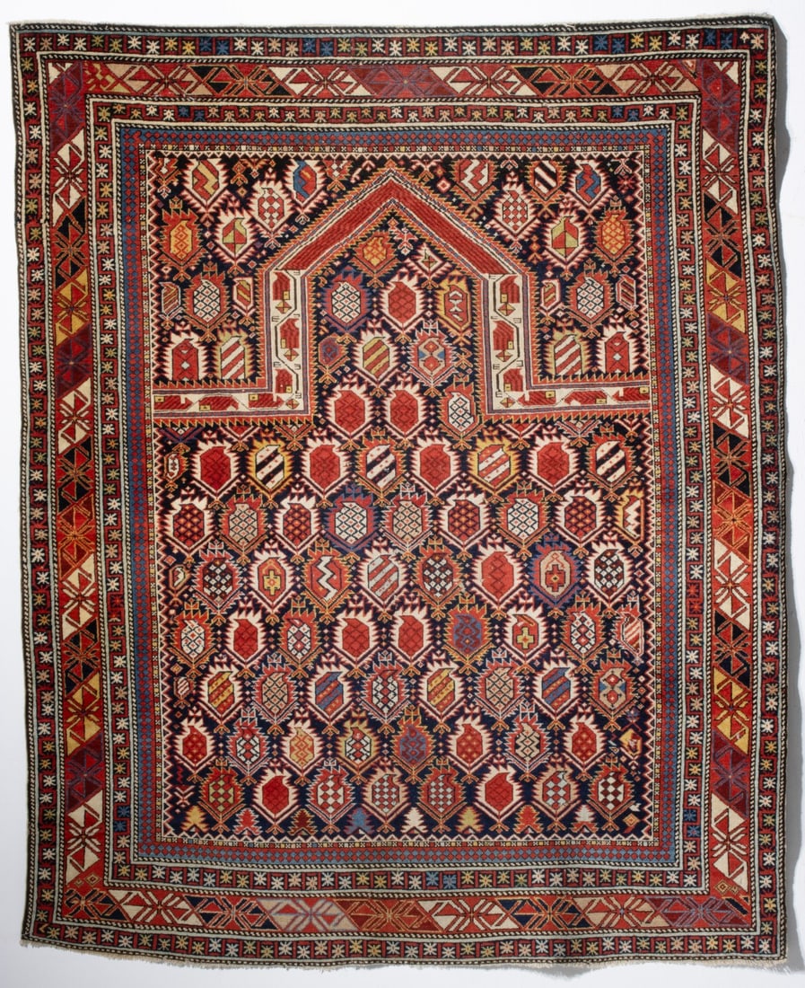 A FINE MARASALI PRAYER RUG, 3RD QUARTER 19TH CENTURY: The dark blue field with offset rows of alternating 'in and out' serrated edged botehs in striped or honey comb form below a pointed ivory arch enclosing hooked block botehs below a solid red chevron