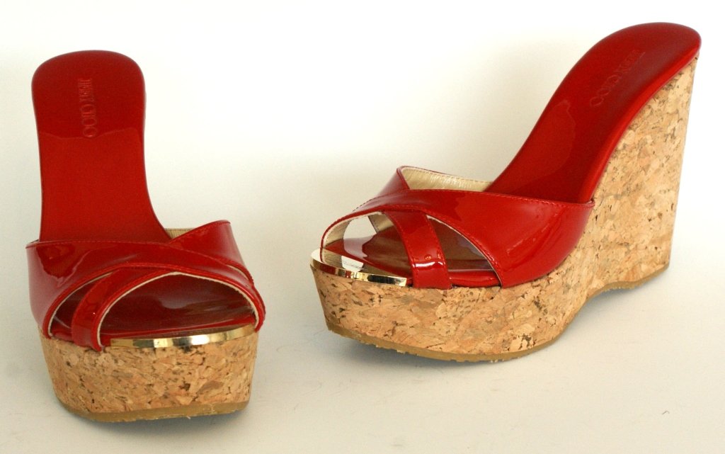 JIMMY CHOO RED PATENT CORK WEDGE SANDAL, SZ 7: Red patent leather slides with red patent cushioned insole, rubber sole, cork wedge heel, metal logo tag at the toe, original box and dust bag. Size 7 (37.5) with heel height of 4 inches and platform