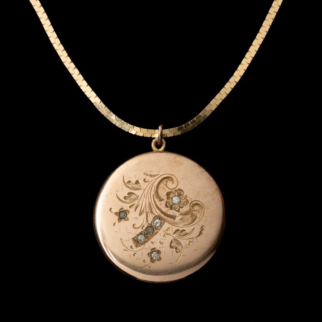 ENGRAVED ANTIQUE LOCKET WITH BRILLIANTS ON 14K CHAIN: The circa 1910 hand engraved gold filled locket set with 'brilliants, as they were described in the old jewelry catalogs, is suspended on a 14k gold brick link chain. The princess length scale link ch