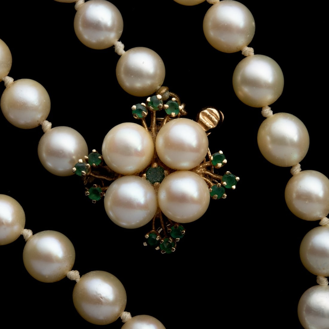 CHOKER LENGTH STRAND OF CULTURED PEARLS WITH 14K GOLD: The 16-inch choker-length strand of uniform cultured pearls, each individually knotted, is completed by a 14K yellow gold floral cluster clasp centering four pearls within a sunburst of 14k gold and g