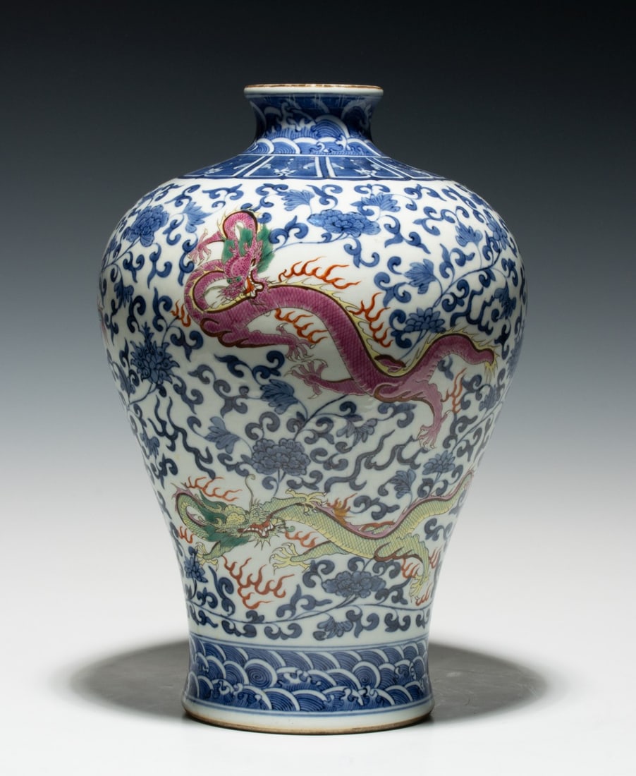 A CHINESE BLUE AND WHITE ENAMELED MEIPING WITH ENAMELS: The ovoid body enameled with iron-red, pink and yellow dragons on a ground of underglaze-blue and white densely scrolling flowers between decorative borders, base with apocryphal six character mark