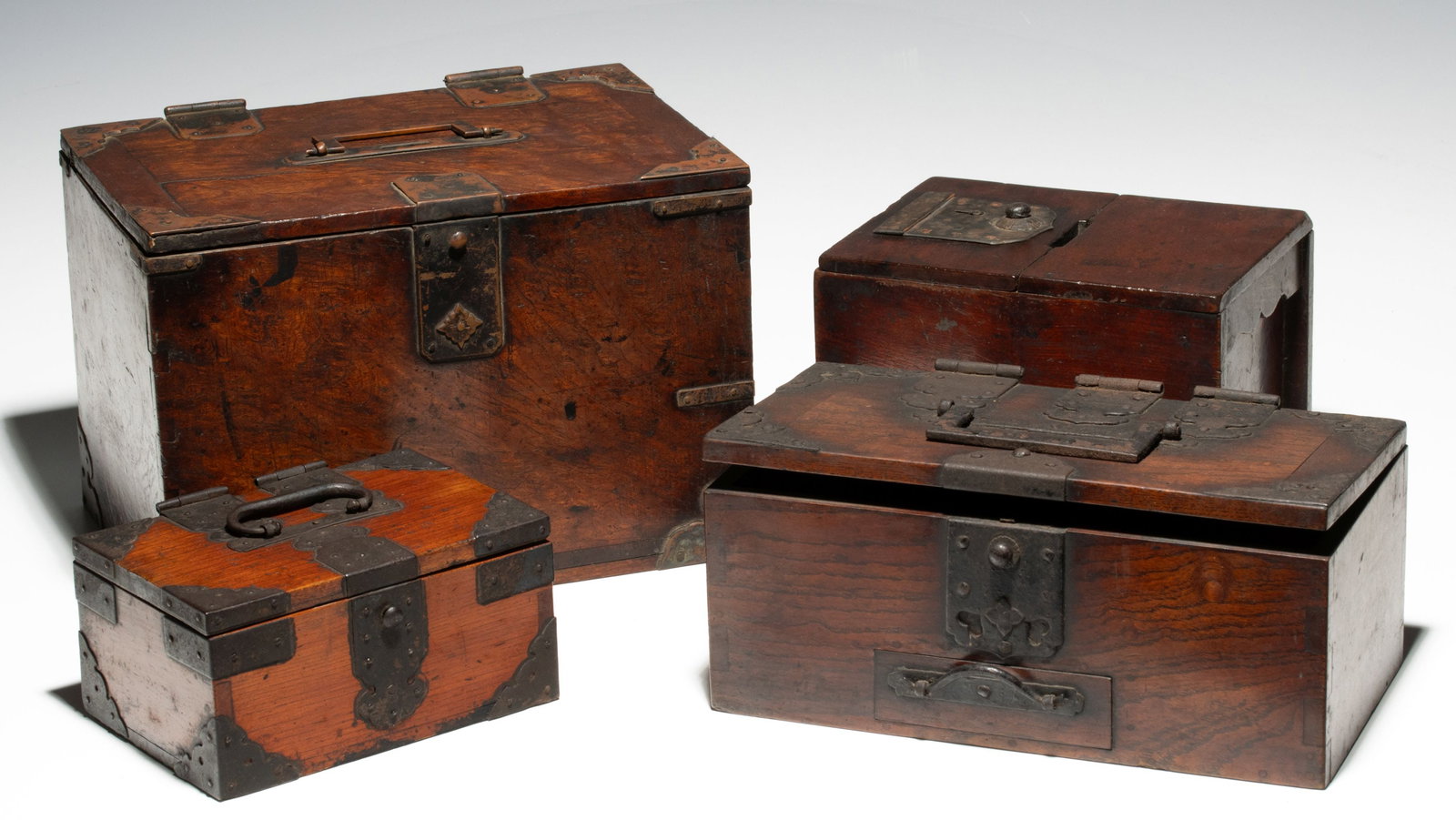 VERY FINE JAPANESE KEYAKI WOOD BOXES WITH METAL MOUNTS: The outstanding group of beautifully patinated keyaki wood boxes from the late Edo to Meiji periods are constructed with both iron and copper mounts, locks and handles. Sizes range from 3 x 6 x 4.25