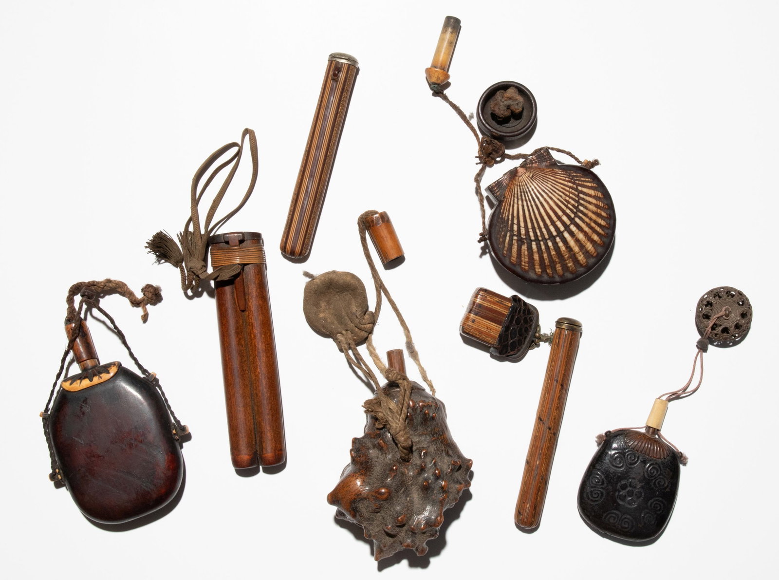 EDO/MEIJI PERIOD JAPANESE POWDER FLASKS AND CONTAINERS: An interesting collection of old and unusual powder flasks fashioned from, and incorporating, shells, leather, root wood and steel. Plus four antique inlaid wood writing utensil cases. Sizes range