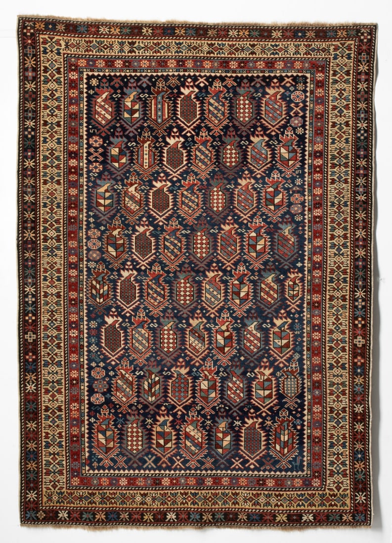 UNUSUAL MARASALI RUG, EAST CAUCASUS, CIRCA 1875: The blue field with all over right facing multifarious serrated polychrome boteh supported by scattered flora forms, within an ivory border enclosing continuous cruciform flower heads, a red flower
