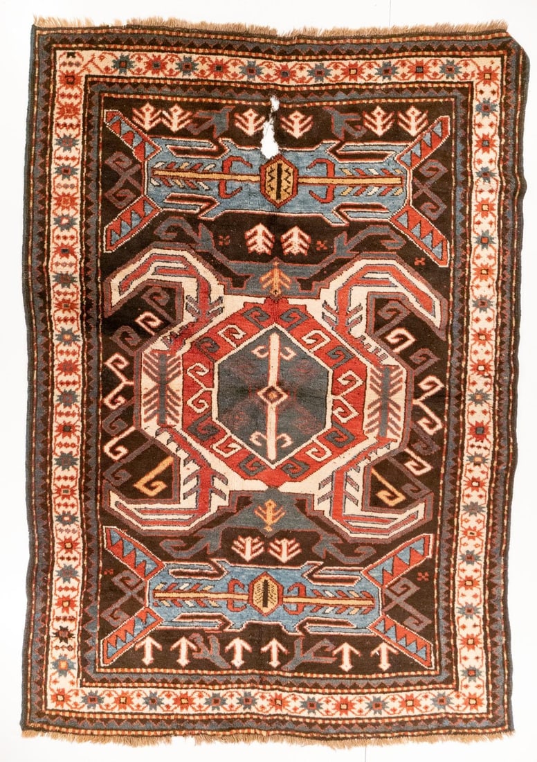LENKORAN RUG, SOUTH CAUCASUS, CIRCA 1880: The charcoal field with a large ivory hooked octagonal medallion enclosing stylised dragons between two pale blue rectangular hooked cartouches, supported by plants within an ivory border enclosing co
