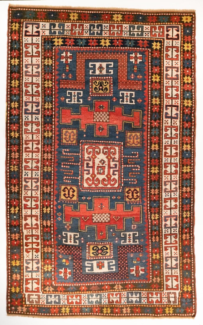 KARACHOV KAZAK DOUBLE NICHE RUG, CIRCA 1875: The pale blue mihrab with a central ivory square hooked medallion, supported by two red stepped cartouche medallions, between two flattened arches, within an ivory border enclosing continuous linked