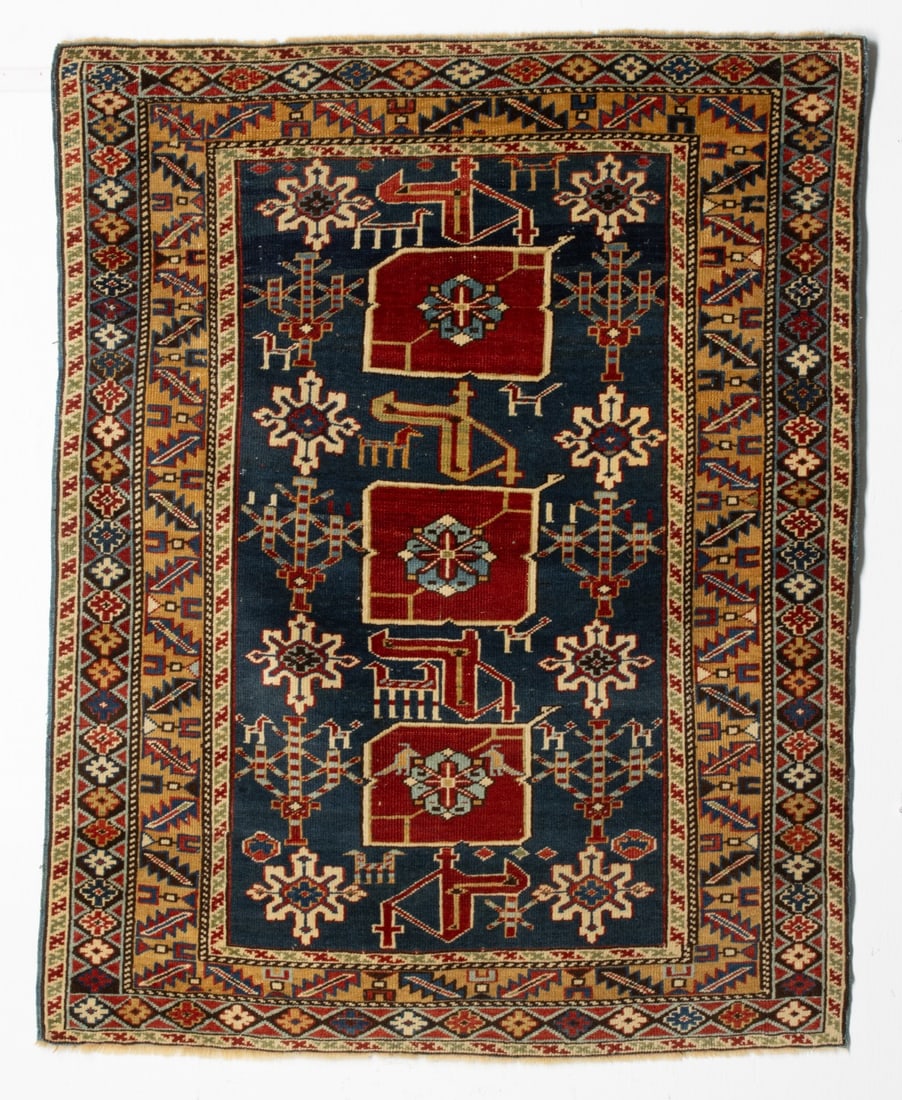 FINE KARAGASHLI RUG, NORTH EAST CAUCASUS, CIRCA 1880: The blue field with three red square medallions each enclosing a pale blue flower head, between hooked arabesques, supported by two columns of stepped ivory flower heads alternating with three branche