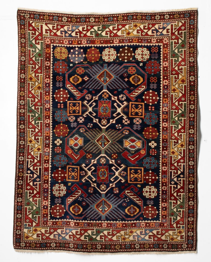 FINE BIDJOV RUG, EAST CAUCASUS, CIRCA 1880: The blue field with a column of three sunburst rhombus medallions, each issuing pairs of hooked arabesques supported by 'Talish' rosettes, flower heads and square tiles, within an ivory border enclosi