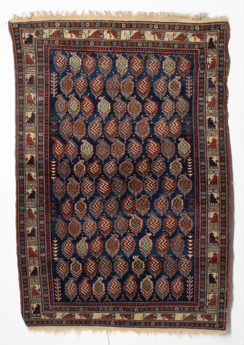 MARASALI RUG, EAST CAUCASUS, CIRCA 1880: The dark blue field with overall offset rows of 'in and out' serrated boteh all with internal zig-zag stripes, between two columns of arrow head plant stems, within an ivory continuous stepped block b