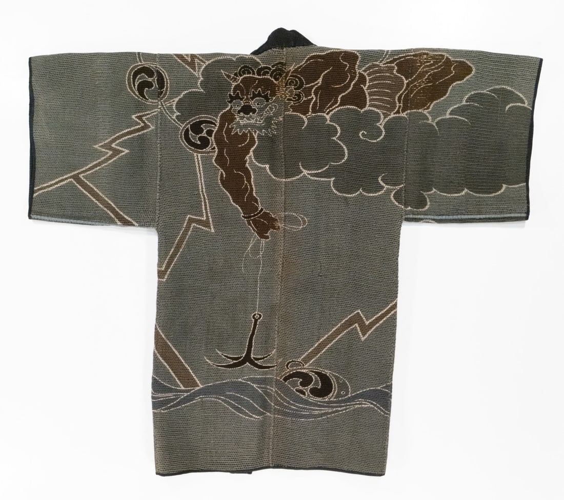 JAPANESE FIREMAN COAT WITH RAIJIN FISHING FOR HIS DRUM: The rare 19th century 'firefighter's' coat, made by hand stitching together multiple layers of loomed cotton fabric using thousands of sashiko stitches, features a crisp design in rich colors