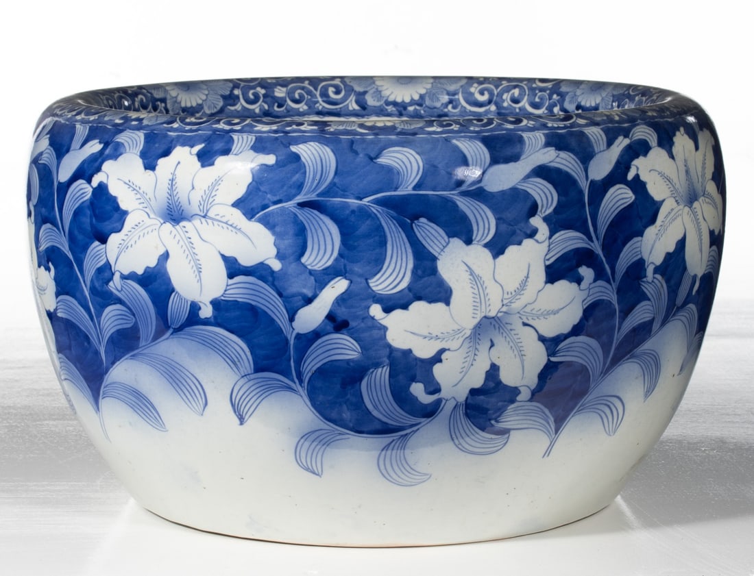 AN EARLY 20C. JAPANESE BLUE & WHITE HIBACHI W/LILIES: The large hand painted blue and white porcelain hibachi is decorated with lilies against a dark hand painted cobalt ground. Measures 10.25 x 118 inches in diameter. Provenance: The estate of John Adai