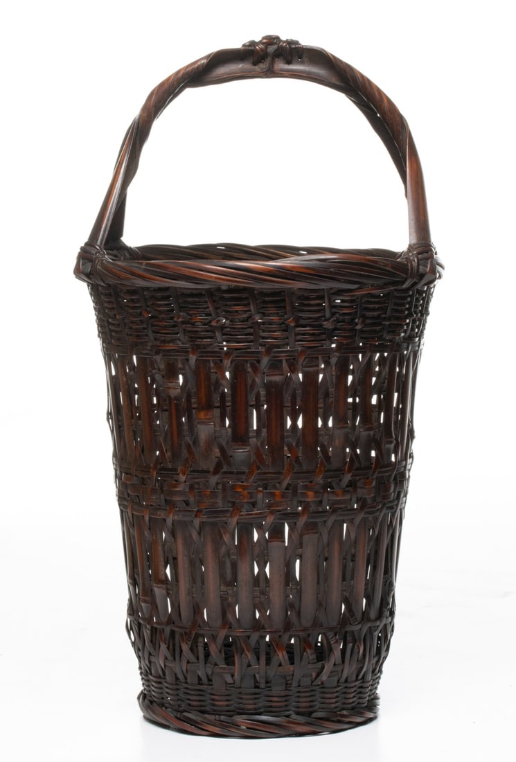 A FINE BAMBOO BASKET SIGNED CHIKUUNSAI, ADAIR ESTATE: The statuesque Japanese bamboo basket for flower arranging displays outstanding patina and a striking, distinctively formed handle created by masterful bending and knotting of bamboo. The handsome for