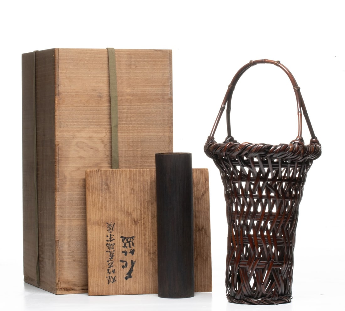 A FLOWER ARRANGING BASKET BY CHIKUUNSAI, ADAIR ESTATE: The finely patinated basket is constructed in a tapered cylindrical form that flares at the heavy, robustly-wrapped rim above the 'Banana Leaf' weave of open-work diagonal plaiting that creates