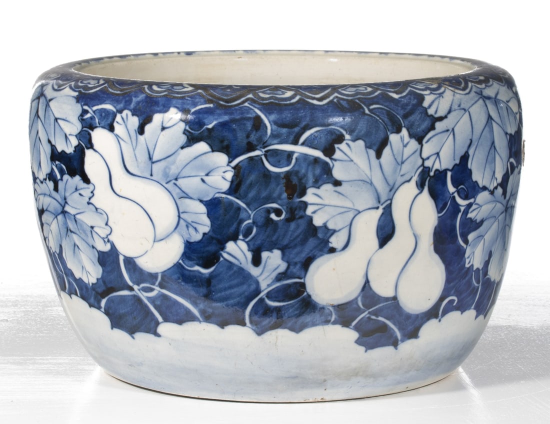 AN EARLY 20C. JAPANESE BLUE & WHITE HIBACHI W/ GOURDS: The large hand painted blue and white porcelain hibachi is decorated with gourds and vines in reverse against hand painted cobalt. Measures 9.5 x 15.5 inches in diameter. Provenance: The estate of Joh