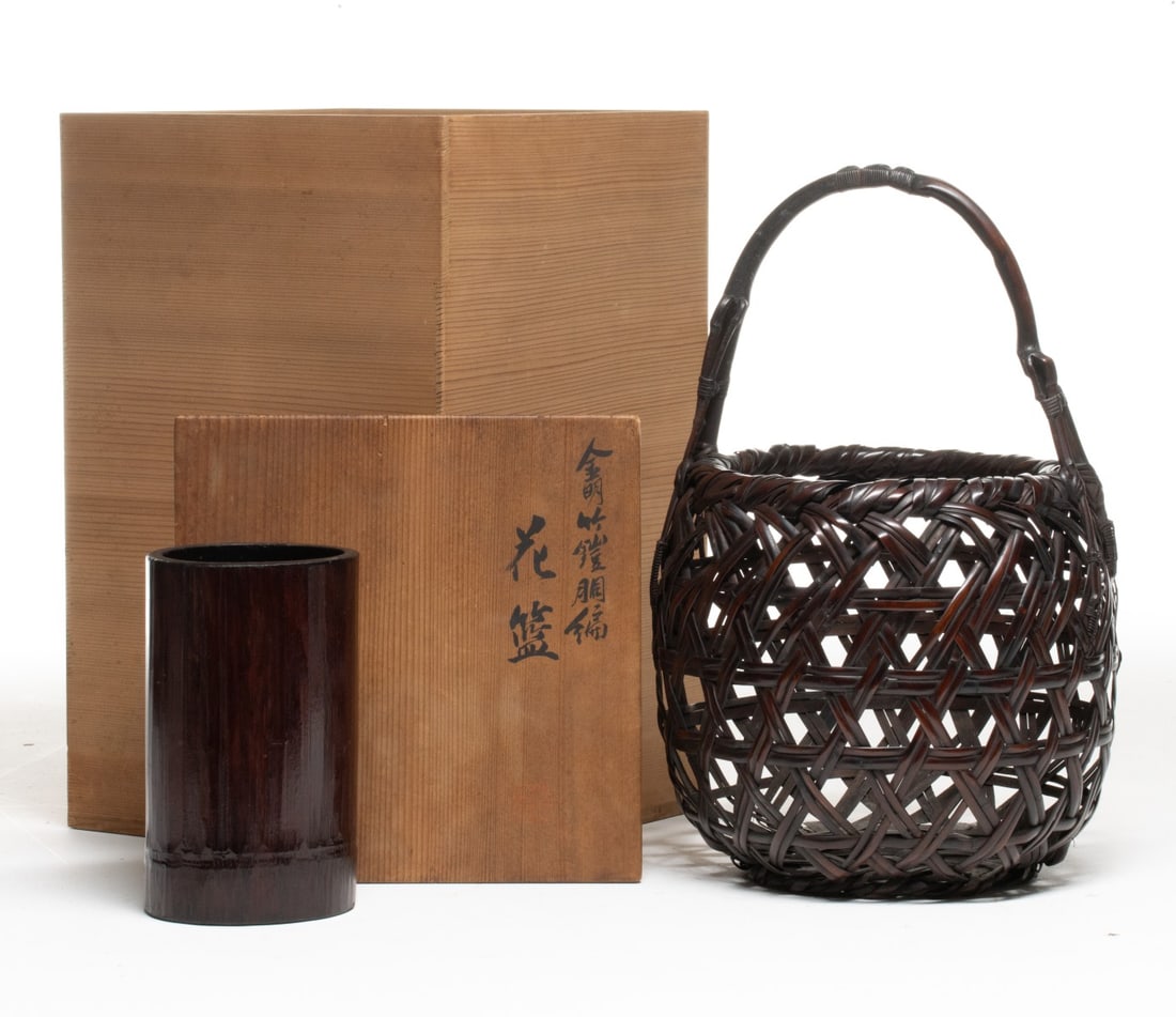 TANABE CHIKUUNSAI OPENWORK IKEBANA BASKET, ADAIR ESTATE: The globular handled basket is constructed using rough weave technique of wide, thick bamboo interlaced in a random overlapping pattern like a bird's nest or a cluster of gnarled vines. The natural ba
