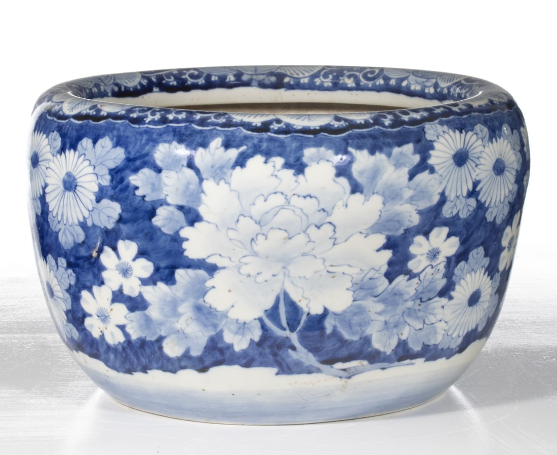 AN EARLY 20C. JAPANESE BLUE & WHITE HIBACHI W/ FLOWERS: The large hand painted blue and white porcelain hibachi is decorated in hand painted cobalt with various flowers depicted in reverse cobalt outline. Measures 9.75 x 15.5 inches in diameter. Provenance