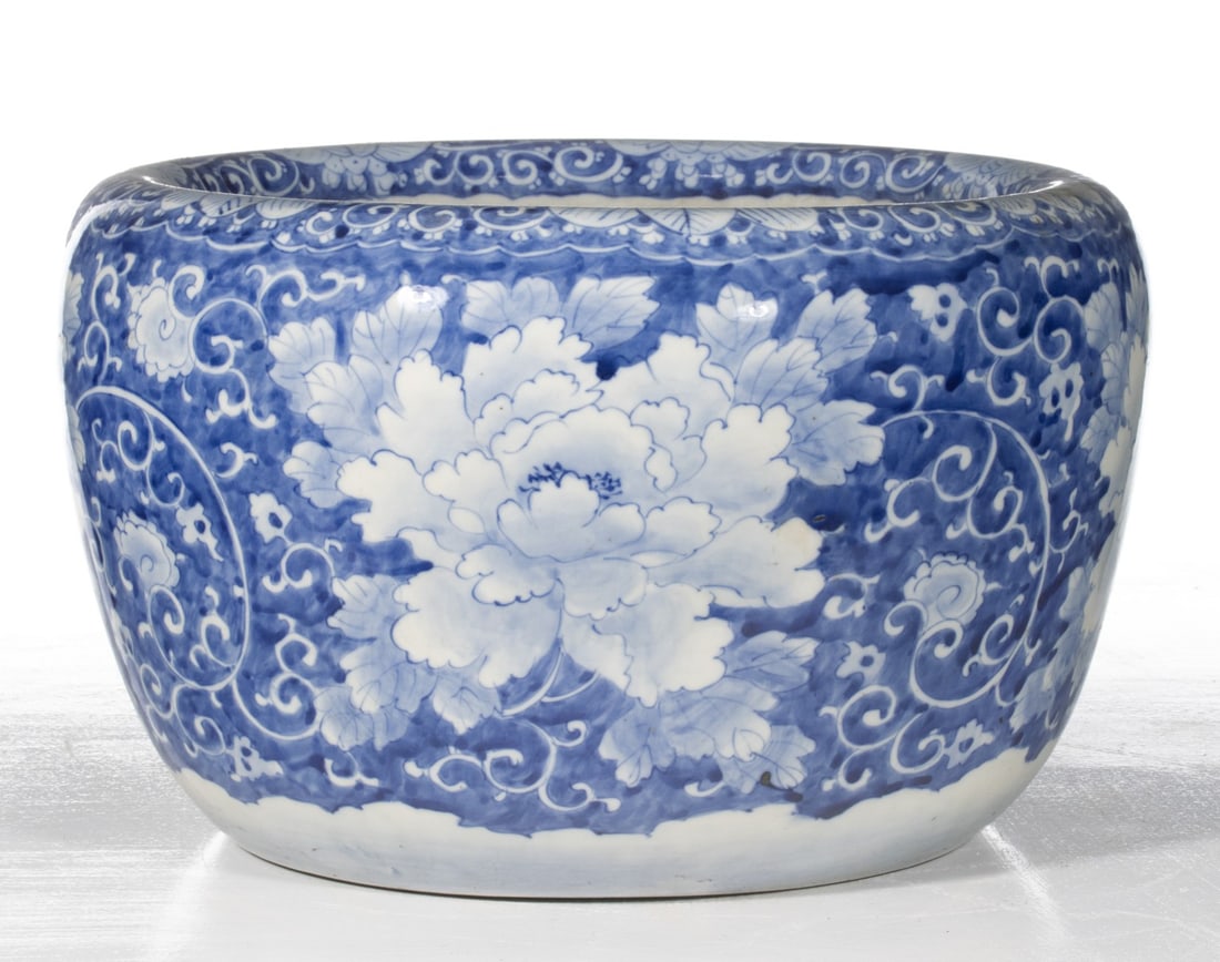 AN EARLY 20C. JAPANESE BLUE & WHITE HIBACHI W/FLORALS: The large hand painted blue and white porcelain hibachi is decorated in chrysanthemums on a ground of hand painted cobalt with swirls in reverse. Measures 9.75 x 15.75 inches in diameter. Provenance: 