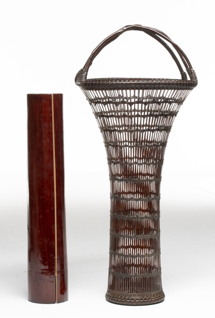 TANABE CHIKUUNSAI TRUMPET FORM BASKET, ADAIR ESTATE: The slender, columnar body of open vertical-stay weave is reinforced by a zig-zag of fine, thin lacing that binds the horizontal and vertical elements. The rim is elaborately reinforced with bamboo wr