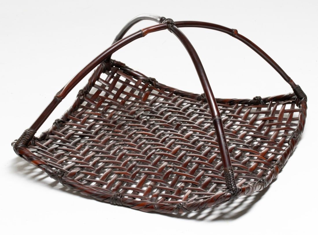 WADA WAICHISAI SIGNED TRAY-FORM BASKET, ADAIR ESTATE: The unusual example in shallow, flared square form is woven in open grid-like foundation. The rim of the basketry tray is wrapped in bamboo and joins a low, arched handle of natural bamboo stalks secu
