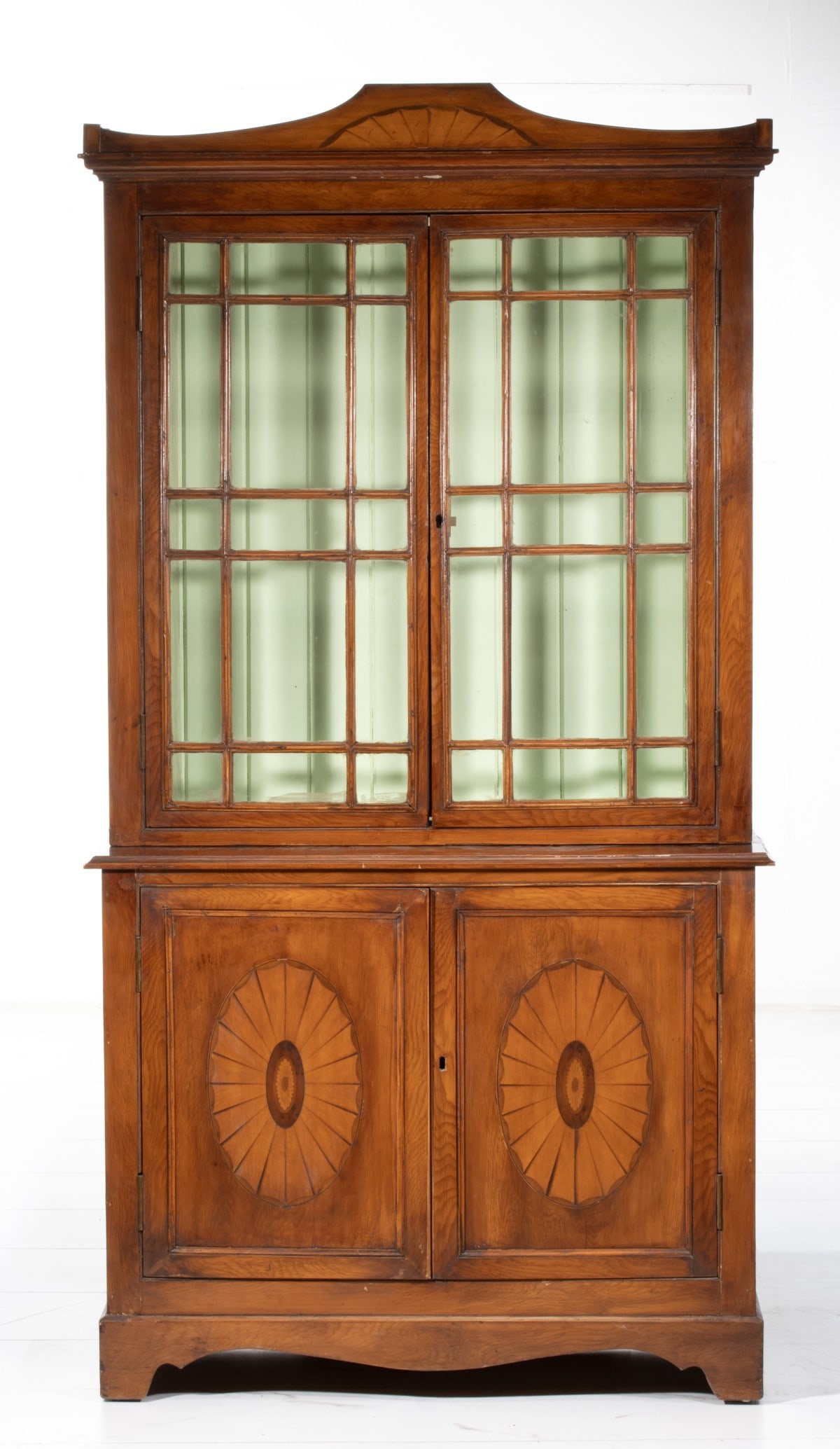 A 19TH CENTURY FRUITWOOD ADAM STYLE DISPLAY CABINET: With inlaid fans and medallions, mullioned glass doors, two shelves, nice smaller size. Measures 72H x 38W x 14D inches. Provenance: The estate of John Adair Jr. (1942-2025), founder and proprietor of