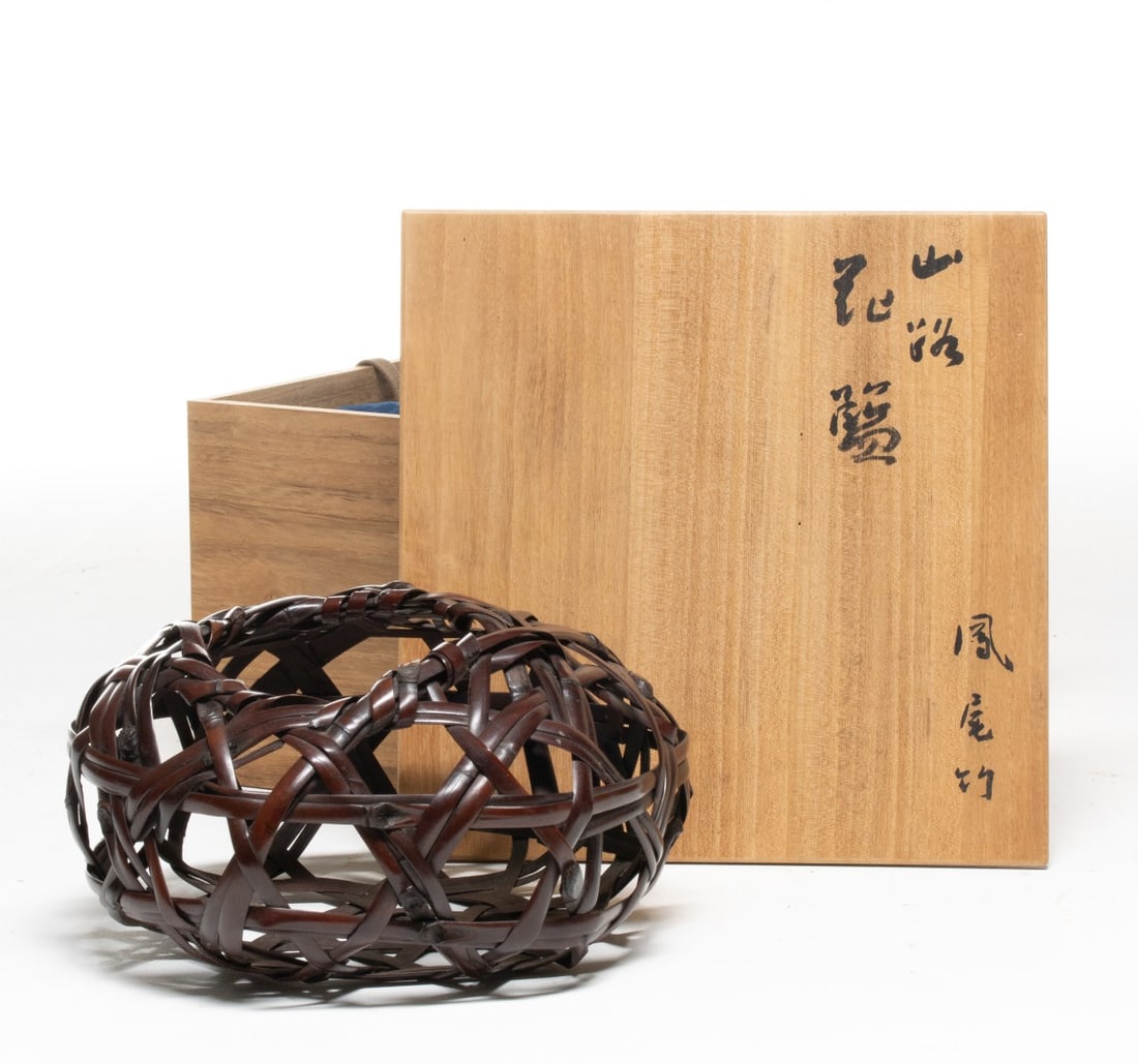 TANABE CHIKUUNSAI II RUSTIC BAMBOO BASKET, ADAIR ESTATE: The interesting example constructed from bamboo slats is layered and interlaced in a dynamic, swirling pattern with the nodes, the natural bumps on the bamboo, prominent and visible on the outside, ad