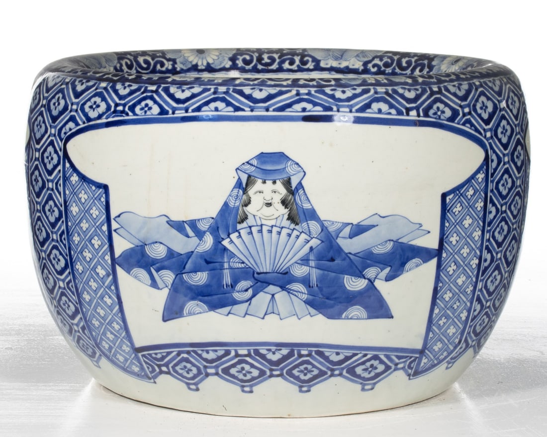 AN UNUSUAL JAPANESE PORCELAIN HIBACHI WITH FIGURE: A three-color Japanese porcelain hibachi pot with picture window and seated woman in kimono holding a fan, blue floral ground. Measures 11.25 x 17.5 inches in diameter. Provenance: The estate of John 