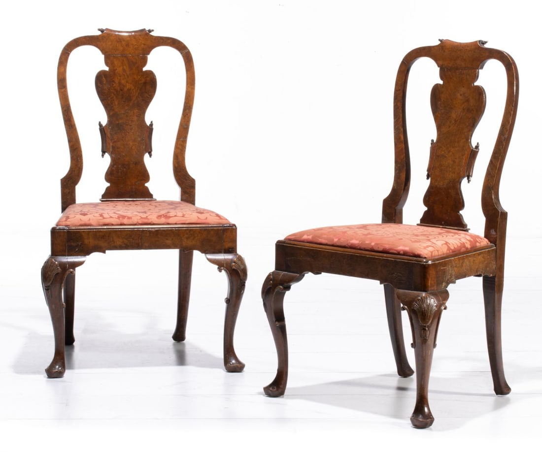 A FINE PAIR OF GEORGE I STYLE BURR WALNUT SIDE CHAIRS: The elegant and well-proportioned pair feature an open backrest with a shaped yoke-form carved scroll cresting rail above the central vase-form splat in matched burr walnut veneers and outward-curving