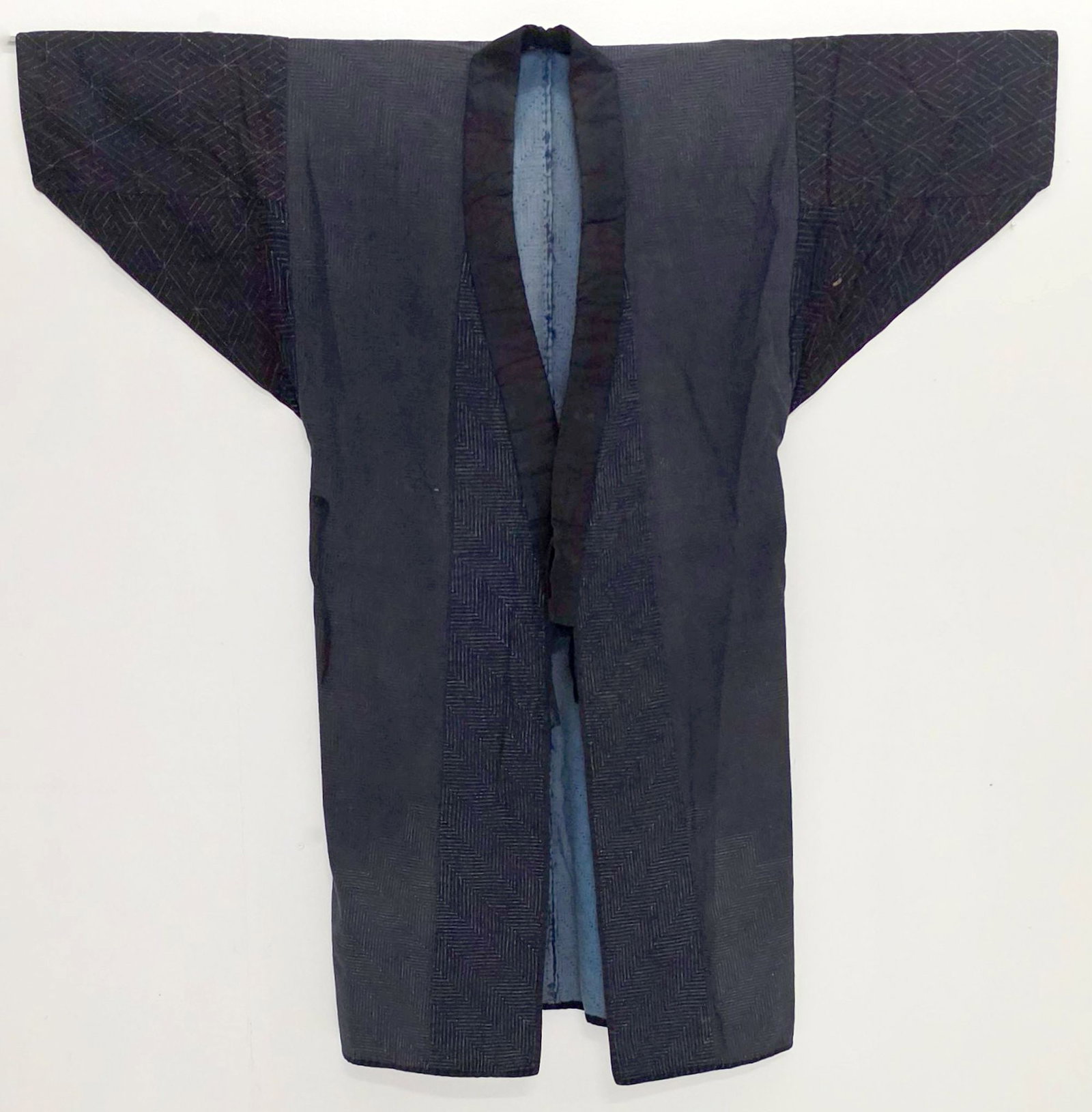 A MEIJI JAPANESE WORK JACKET WITH SASHIKO QUILTING: The late 19th to early 20th century has contrasting indigo dyed geometric patterns and overall sashiko stitch. Measures 50.5 x 48 inches. Provenance: The estate of John Adair Jr. (1942-2025), founder 