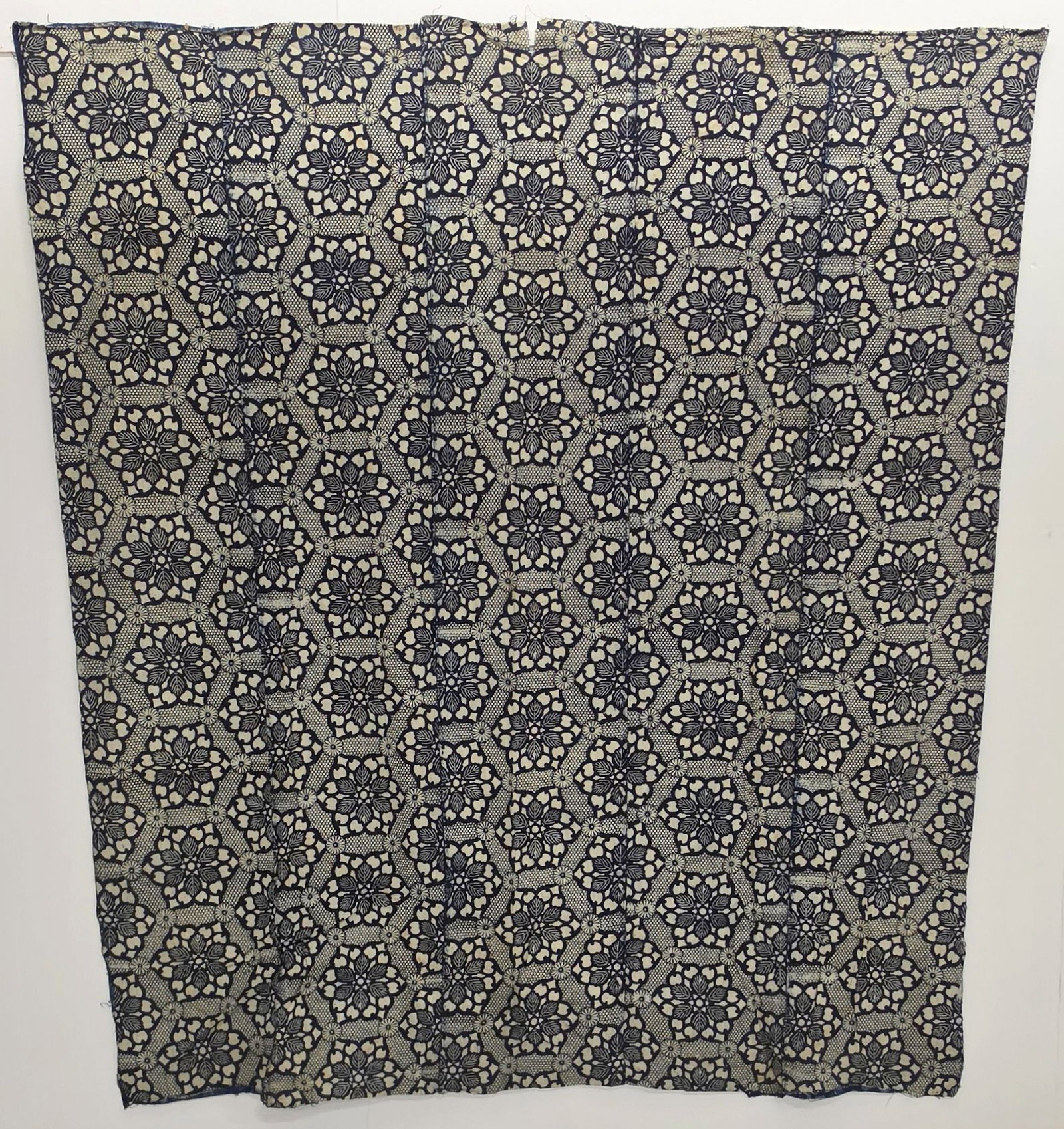 A JAPANESE DOOR HANGING AND TWO STENCIL DYED PANELS: Three antique textiles as shown. 1. Door hanging measures 67.25 tall including the loops by 73 inches across the top. 2. Chrysanthemum fabric measures 70 x 63 inches. 3. Fabric with the dot pattern