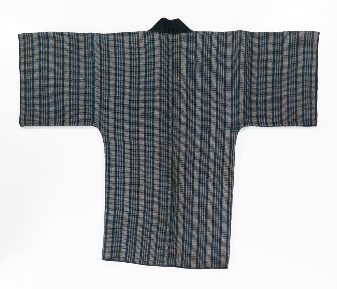 A JAPANESE SASHIKO-STITCHED STRIPE DESIGN LINER GARMENT: The late 19th to early 20th century Indigo dyed garment is of tsutsugaki dyed cotton. Measures 38.5 x 48 inches. Provenance: The estate of John Adair Jr. (1942-2025), founder and proprietor of Kurofun