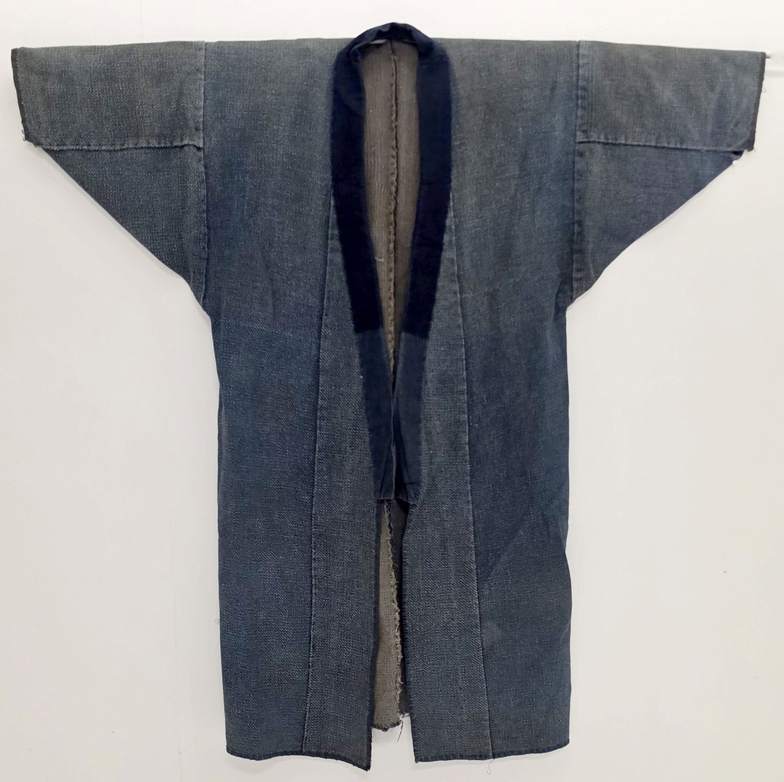 A MEIJI JAPANESE WORK JACKET OF JOINED INDIGO PANELS: The traditional farmer's or worker's jacket is constructed from random cloth panels assembled from many different fabrics demonstrating the thrift of the maker. Measures 49 x 48 inches. Provenance: Th