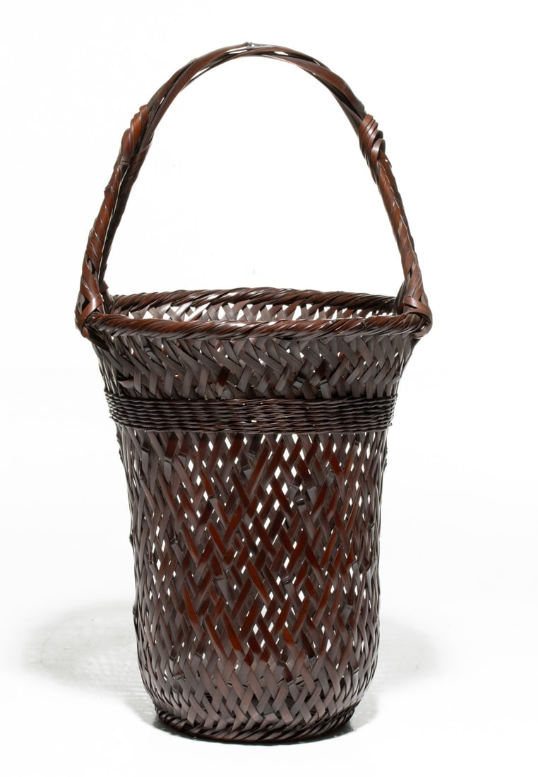 WADA WAICHISAI III BAMBOO IKEBANA BASKET, ADAIR ESTATE: The tall cylindrical hanging flower basket is constructed in openwork diamond lattice rising to an upper shoulder woven in a wide band of dense, finely coiled rattan wrapping above which the body flar