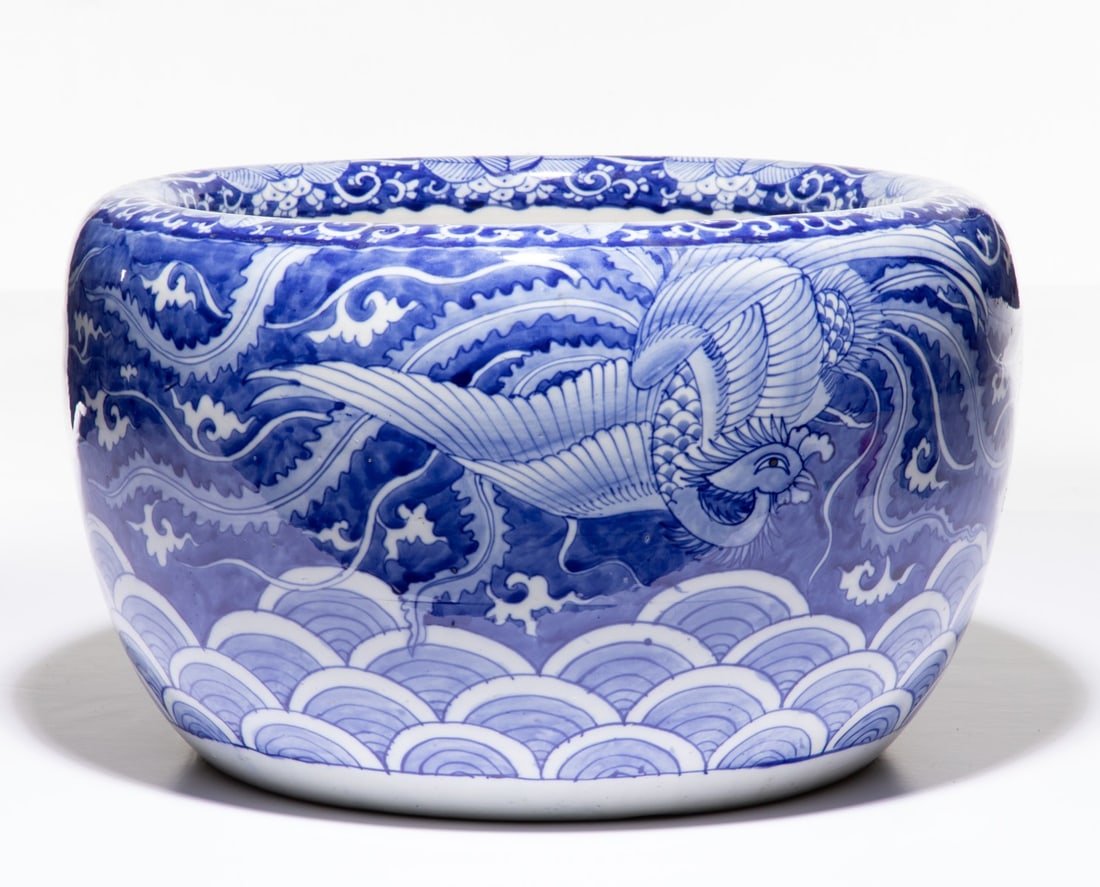 AN EARLY 20C. JAPANESE BLUE & WHITE HIBACHI W/ PHOENIX: The large hand painted blue and white porcelain hibachi is decorated with design of a soaring phoenix over stylized waves. Measures 10.5 x 17.5 inches in diameter. Provenance: The estate of John Adair
