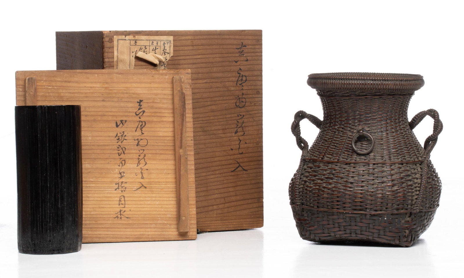 AN INTERESTING AND FINELY WOVEN BAMBOO FLOWER BASKET: The Chinese style basket of extremely fine plait weaving bordered by raised corded vertical ribs and horizontal rattan bands is fitted with twin, decoratively coiled side handles and a brass or bronze